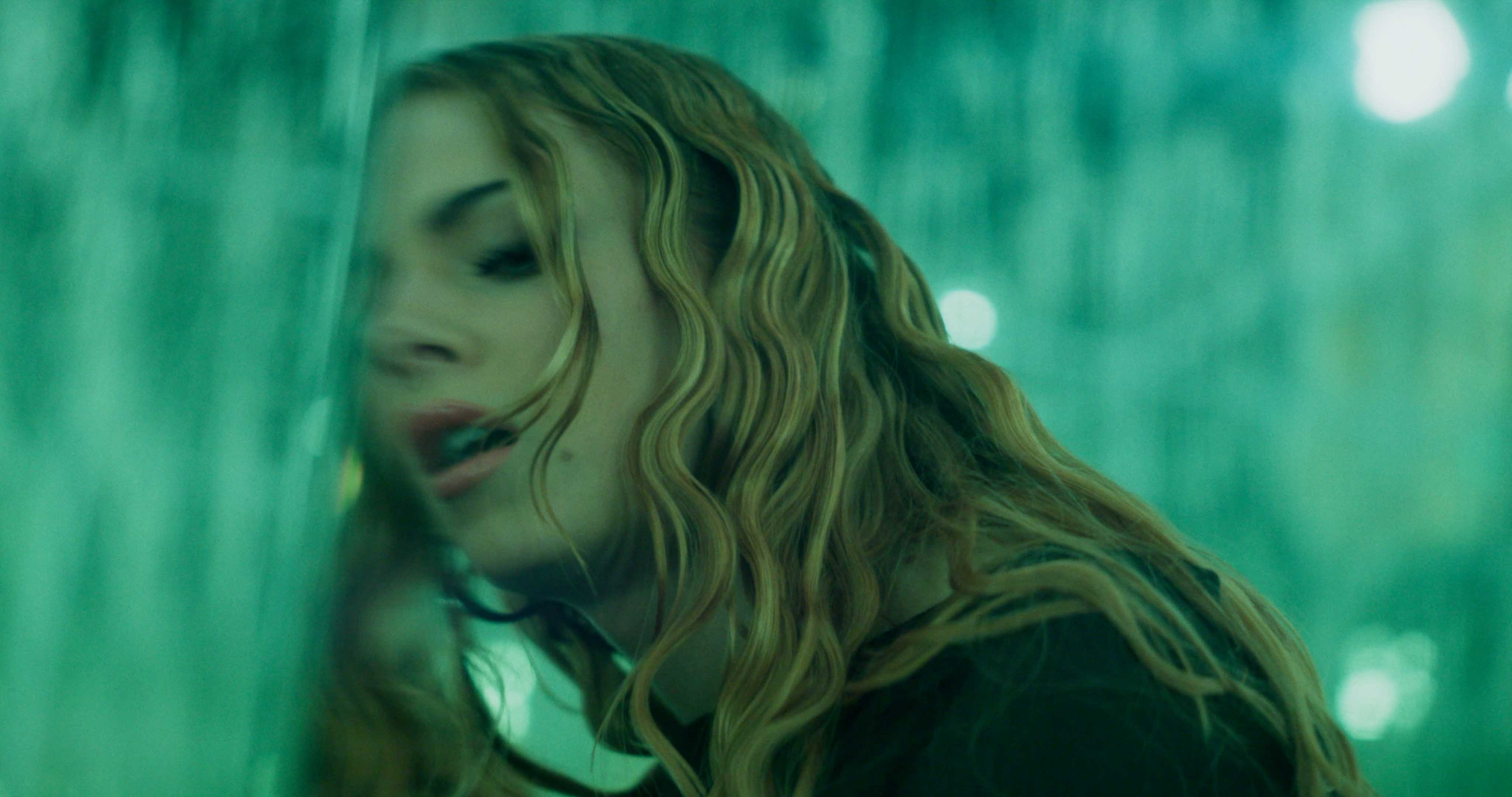 Abstract motion-blur of red and white kerb stripes on dark asphalt, evoking racetrack speed.